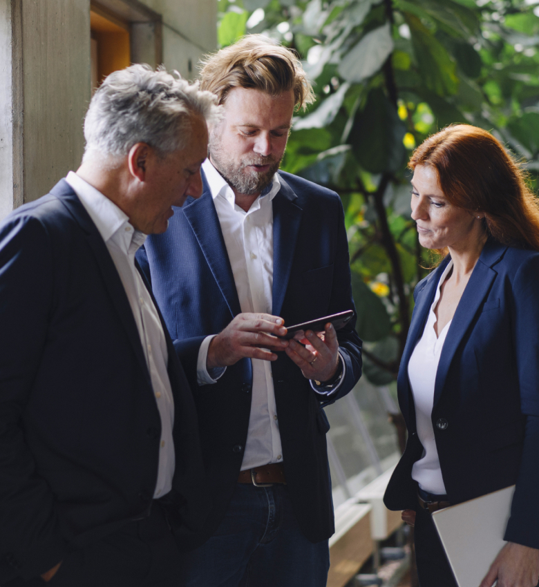 Three people in business suits conversing.